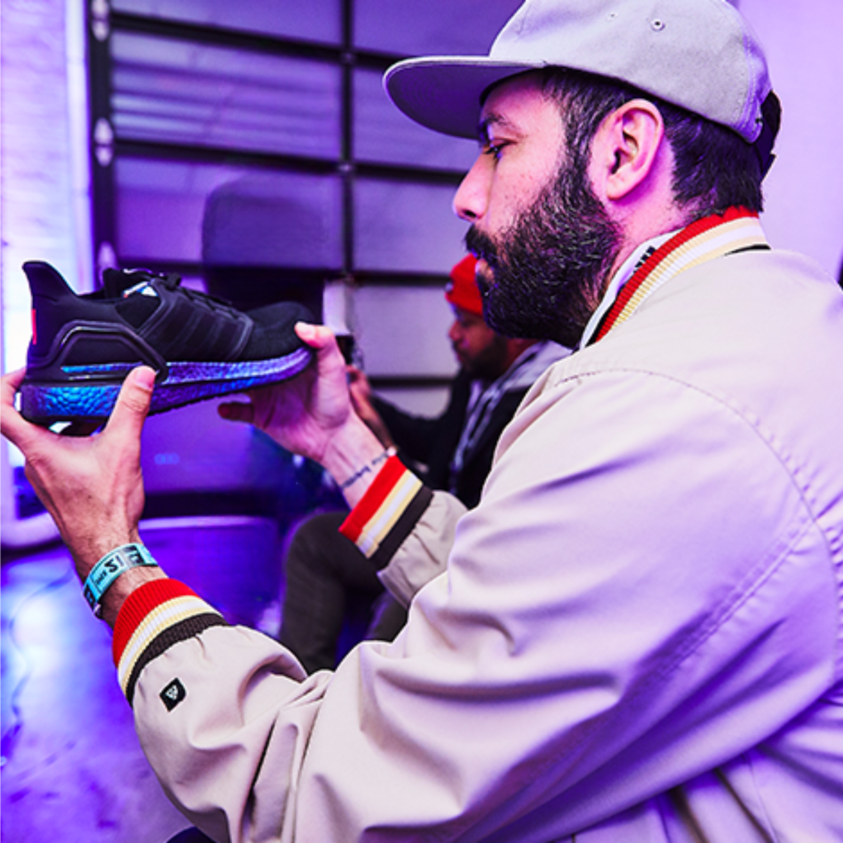 Guest examines an adidas sneaker under purple lighting during the Goodbye Gravity event.