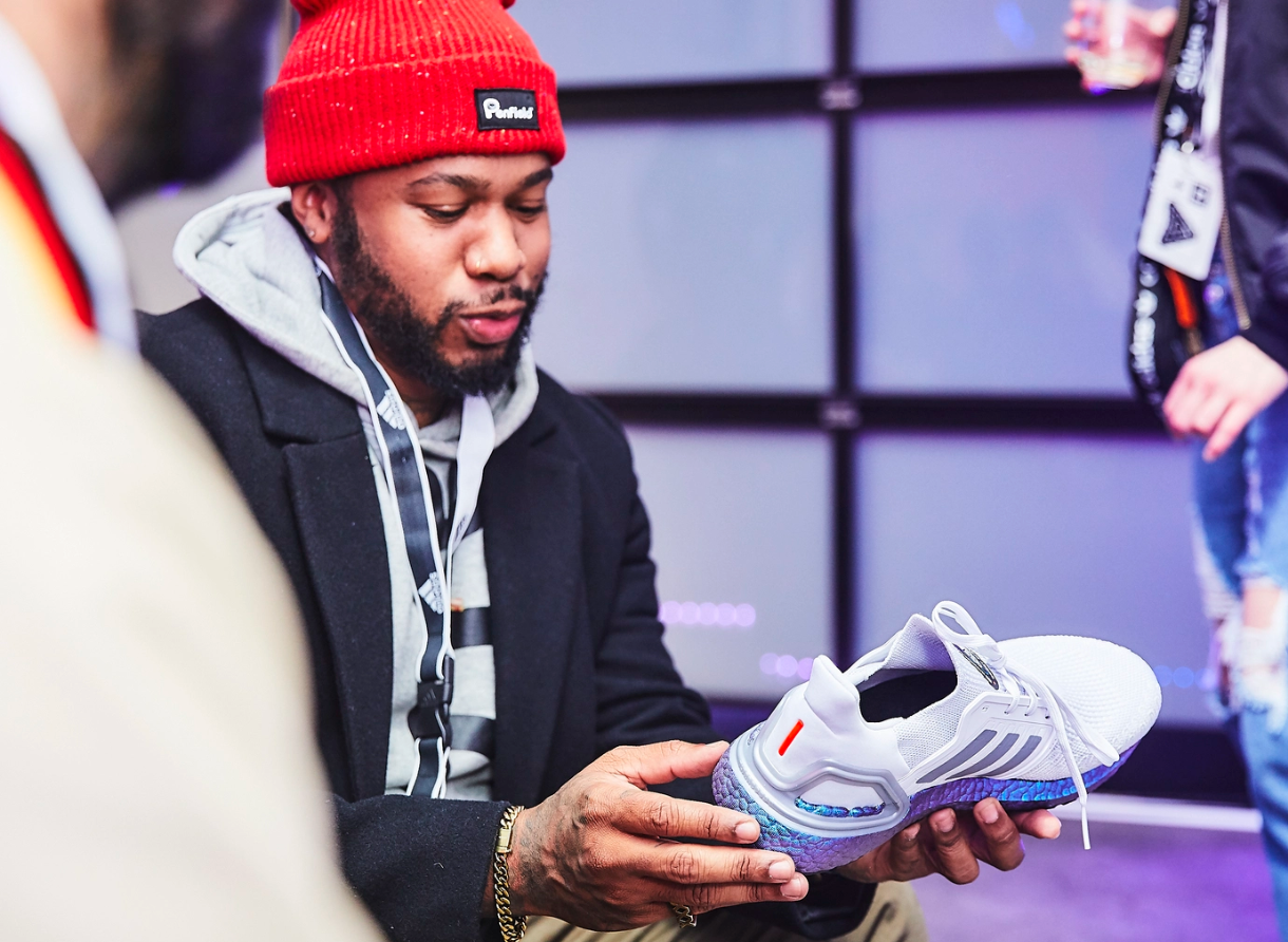 Guest closely examines an adidas Ultraboost sneaker during the Goodbye Gravity immersive event.