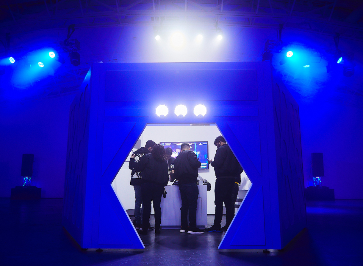 Guests enter a futuristic installation structure illuminated in blue lighting at Goodbye Gravity.