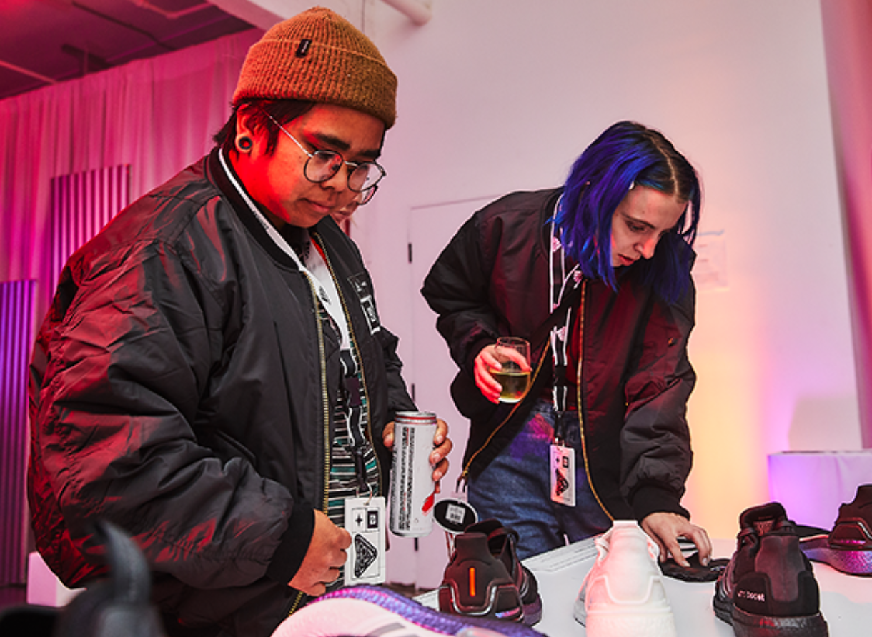 Attendees review adidas footwear at a curated product display during the Goodbye Gravity event.