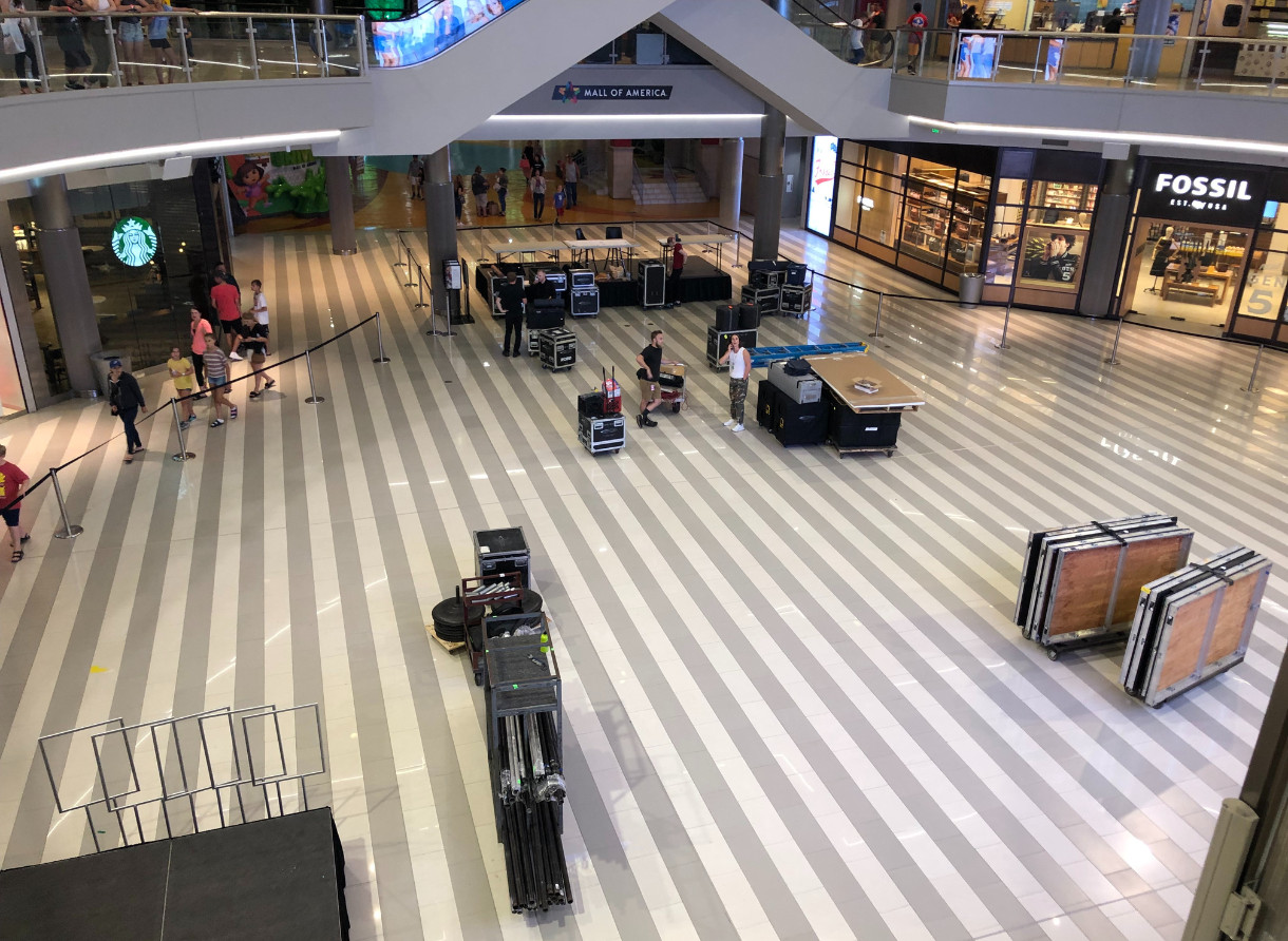 Event production equipment being set up inside a large shopping center before doors open.