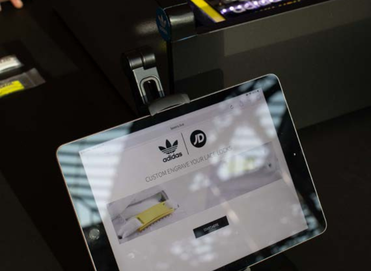 Tablet screen displaying adidas and JD branding for a custom engraving experience.
