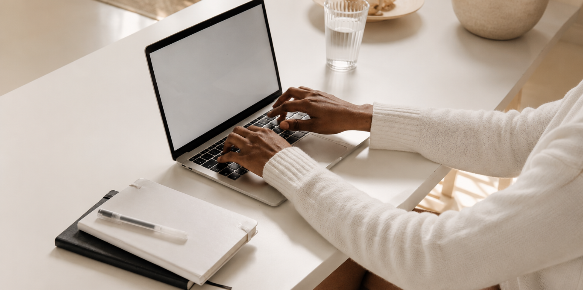 Professional working on a laptop at a clean, minimalist desk in warm natural light, representing thoughtful work, credibility, and a strong professional reputation.